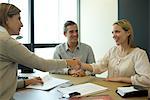 Businesswoman shaking hands with client in office