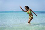 Young woman in bikini splashing water in ocean