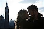 UK, London, Young couple kissing, Big Ben in background