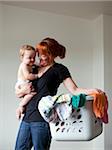 USA, Utah, Orem, Mother holding baby (6-11 months) and laundry basket