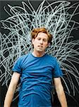 Studio portrait of man with chalk scribble on blackboard