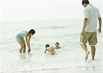 Family at the beach, playing in the water