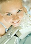 Girl holding armful of presents, high angle view