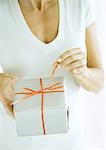 Woman pulling ribbon on present