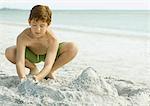 Garçon jouant dans le sable sur la plage