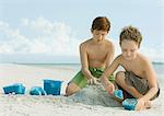Garçons, construire des châteaux de sable sur la plage