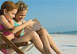 Mädchen zusammen am Strand Buch zu lesen