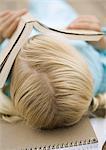 Girl lying with book covering face