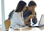 Businesswoman and man working with laptop