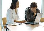 Businesswoman and man working with laptop