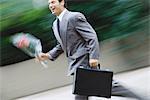 Businessman running with bouquet of flowers
