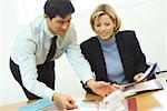 Business colleagues, man leaning over woman's shoulder