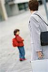 Businesswoman walking away from son