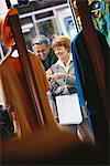 Mature couple looking through shop window, laughing