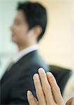 Man's hands, businessman in blurred background