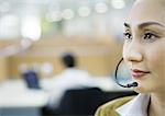 Businesswoman wearing headset in office, focus on foreground