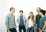 Group of young adult and teenage friends standing together, white background