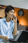 Young man using laptop and cell phone