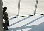 Businesswoman leaning against column, high angle view