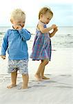 Two toddlers standing on beach