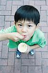 Boy eating sweet snack, smiling at camera