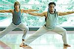 Young men doing side lunge in exercise class