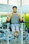 Man doing leg lifts with exercise machine