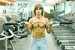 Man lifting barbell in weight room, front view