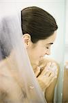 Woman in shower, washing shoulder