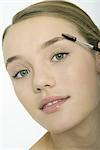 Teenage girl brushing eyebrows