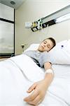 Boy lying in hospital bed