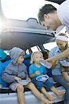 Children eating meal in back of car