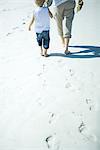 Enfant et adulte marchant sur le sable de faible section