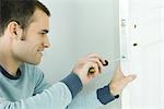 Man removing lock from door