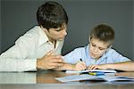 Man helping boy with homework