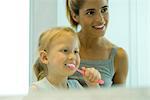 Femme aidant se brosser les dents petite fille