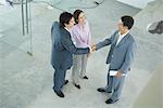 Young couple shaking hands with real estate agent, high angle view