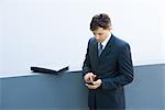 Young businessman using palmtop, looking down, high angle view