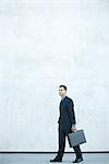 Businessman walking, carrying briefcase, full length