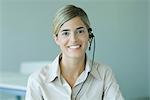 Young woman wearing headset, smiling at camera, portrait