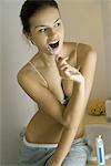 Jeune femme en sous-vêtements se brosser les dents, à la recherche de suite