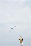 Man flying kite, looking up