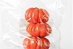 Heirloom tomatoes stacked in plastic bag, close-up