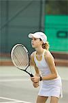 Teenage girl playing tennis, looking away