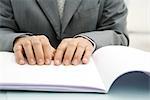 Professional man reading Braille, cropped view of hands