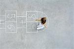 Girl playing hopscotch, overhead view