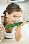 Woman smelling fresh chives, smiling at camera