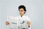 Young business man reading newspaper