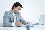 Young businessman working at desk, puffing cheeks