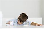 Boy wiping up spilled milk with towel